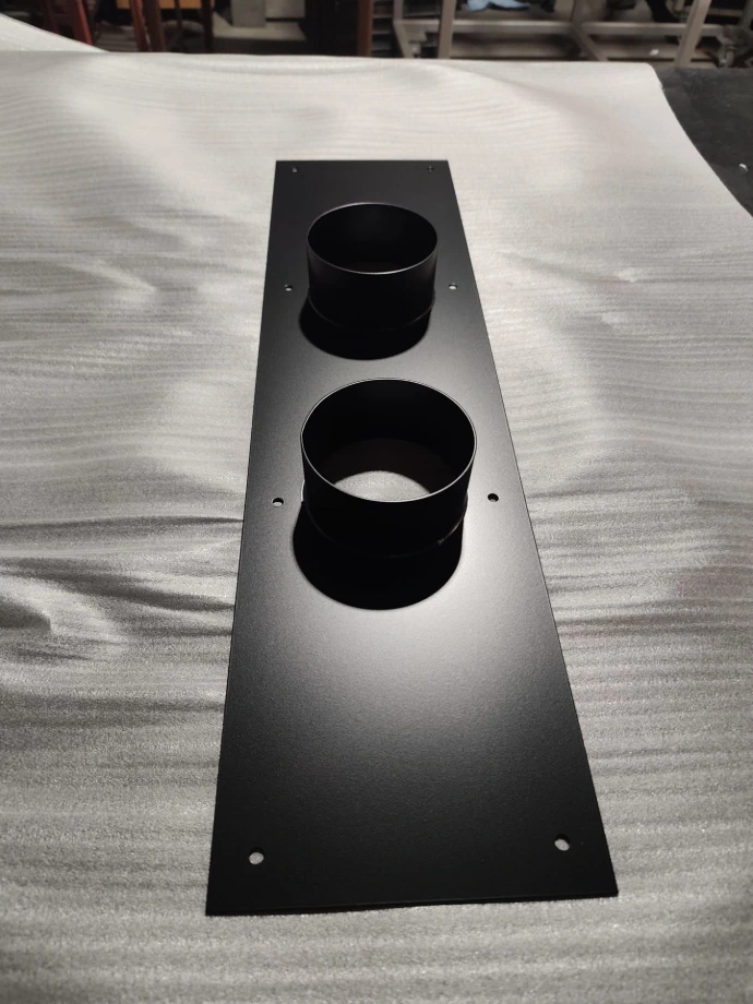 Steel panel with two welded cylindrical collars and matte black powder coating